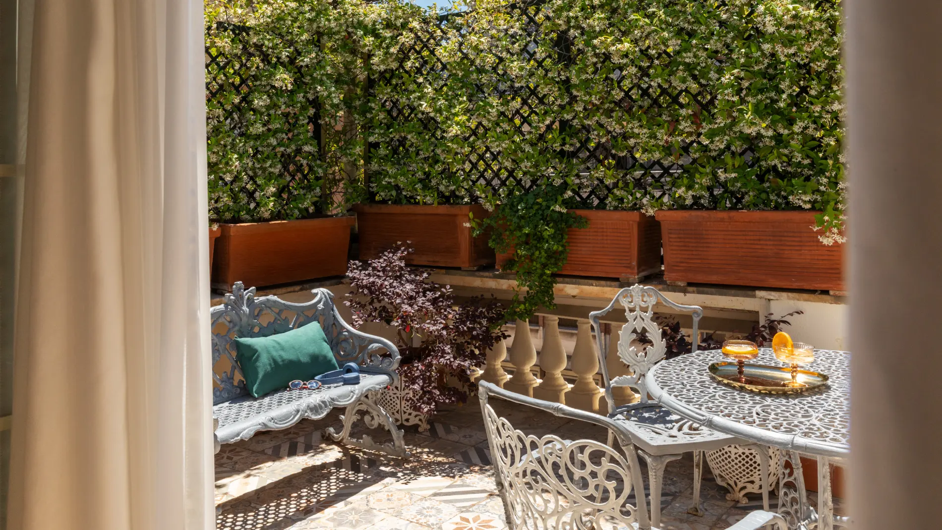 Private terrace with wrought-iron table and chairs, flowering plants and natural light in Rome - The Hotel Britannia, BZAR hotels in Rome