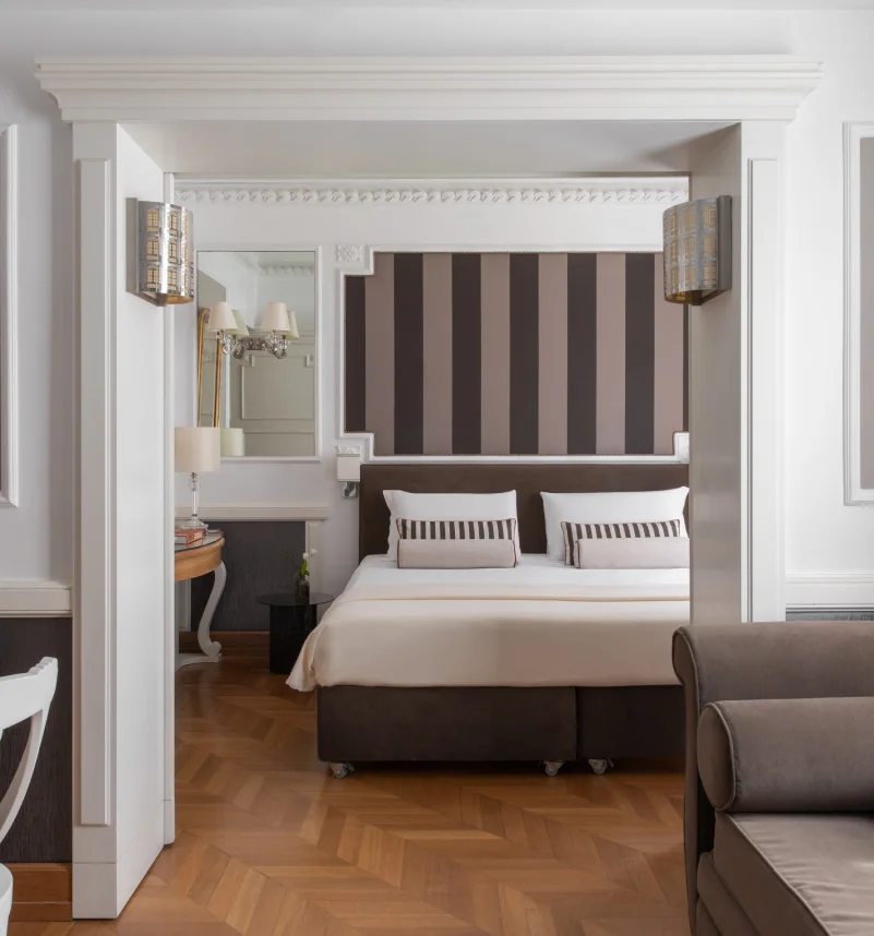 Elegant suite with double bed, striped headboard, sofa and herringbone parquet near the Rome Opera House - The Hotel Britannia, BZAR hotels in Rome