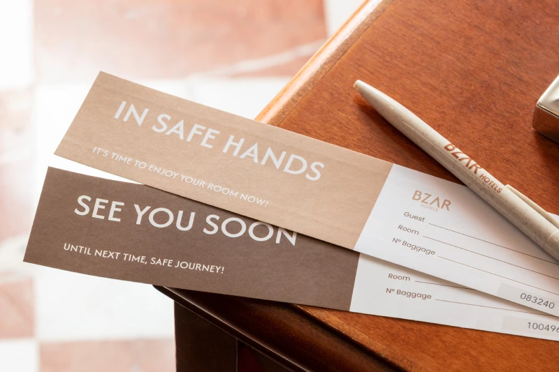 Hospitality detail with BZAR hotels cards, pen, luggage receipts and welcome messages in Rome - The Hotel Britannia, BZAR hotels in Rome