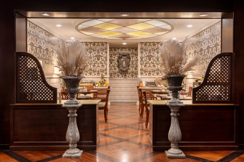 Breakfast room entrance with ornamental vases, wood panelling and geometric floor in Rome - The Hotel Britannia, BZAR hotels in Rome